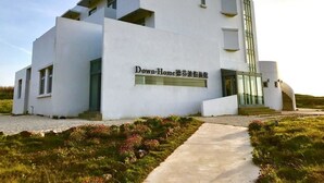 A modern, white building with a flat roof and large windows, labeled "Down-Home".