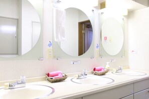A bathroom with three sinks, each with a mirror above. There are baskets with pink towels and toiletries on the counters. - Cottage EMI (Kyoto)