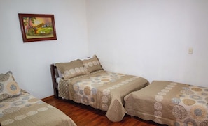 A small, simple room with two single beds and a wooden floor. - Hotel del Turismo (Santa Rosa de Cabal)