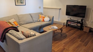Un salon avec un canapé, une table basse et un téléviseur.