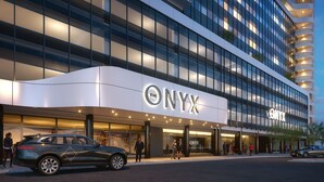 Un hotel moderno con fachada curva, grandes ventanales de vidrio y un llamativo letrero 'ONYX'.