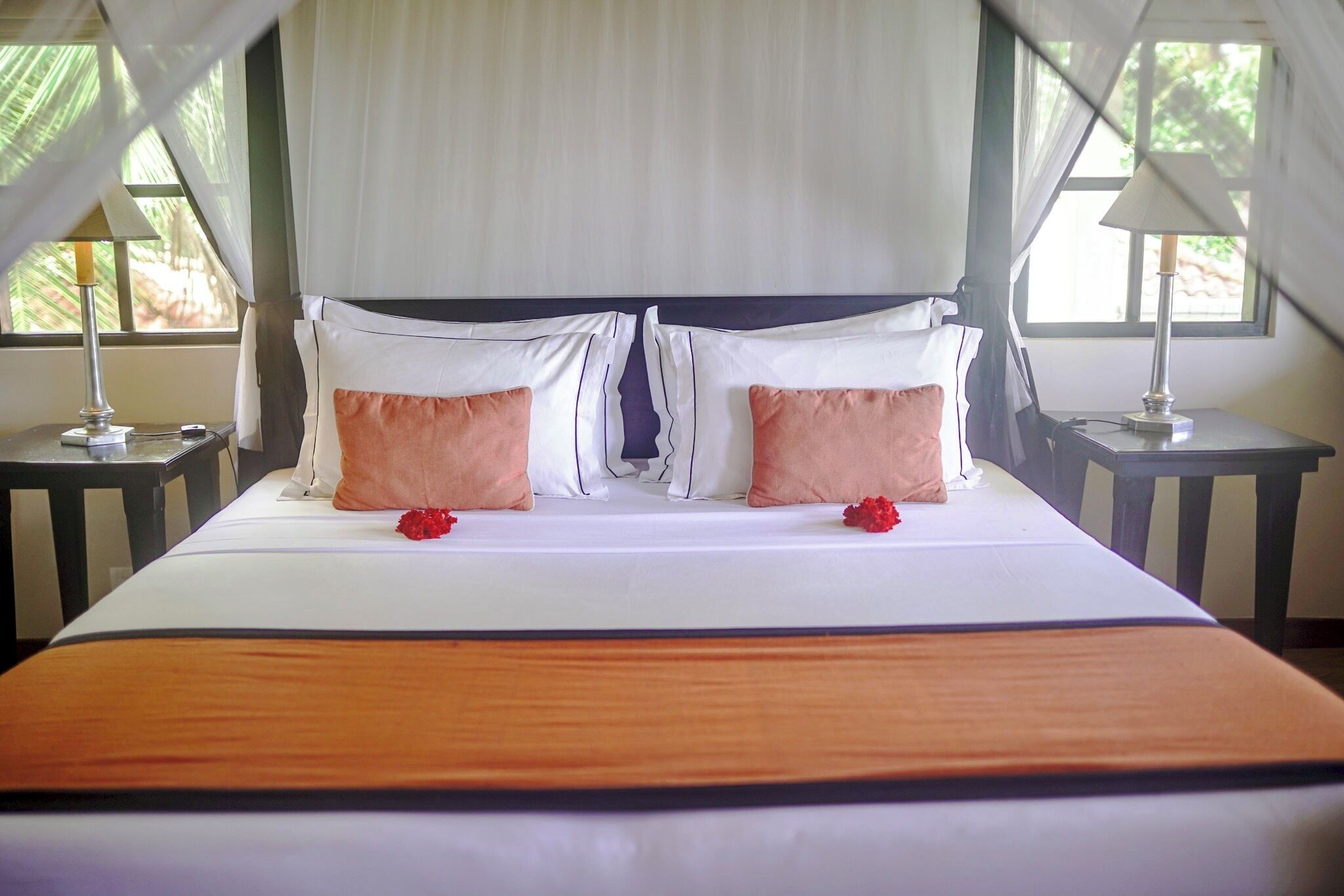 Un letto a baldacchino, due comodini e vista sul verde circostante.