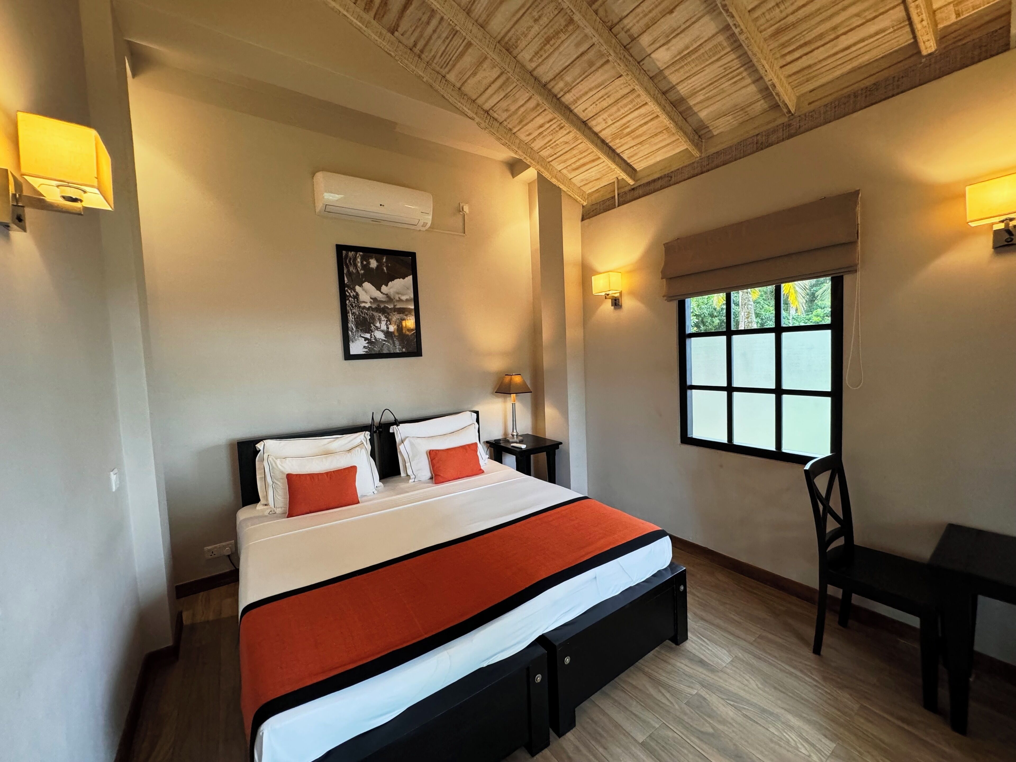 Une chambre à coucher avec un lit, des tables de chevet, une fenêtre et une chaise.