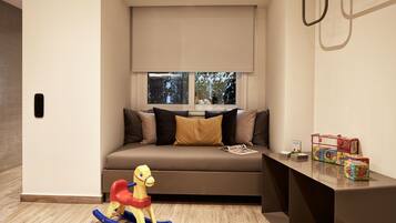A modern living room with a sofa, a rocking horse, and a table with toys.