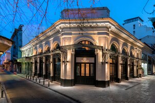 A historic building with a classic facade, large arched windows, and a prominent entrance.