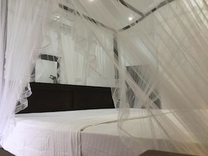 A bedroom with a bed covered by a sheer white canopy. - Galle Fantacy (Unawatuna)