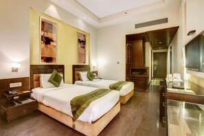 A hotel room with two beds, a desk with a telephone, and a television. - Hotel Western Court (Panchkula)