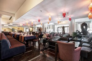 A spacious lounge area with multiple seating options, including sofas and chairs, arranged around a central coffee table. - Hotel Western Court (Panchkula)