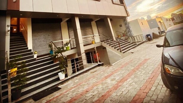 A hotel with a modern facade, multiple floors, and a staircase leading to the entrance. - Hotel Western Court (Panchkula)