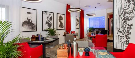 A modern dining area with red chairs, a wooden table, and a menu.