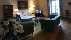 A living room with a sofa, a coffee table, a TV, and a painting on the wall. - Oriuolo Giotto (Florence)