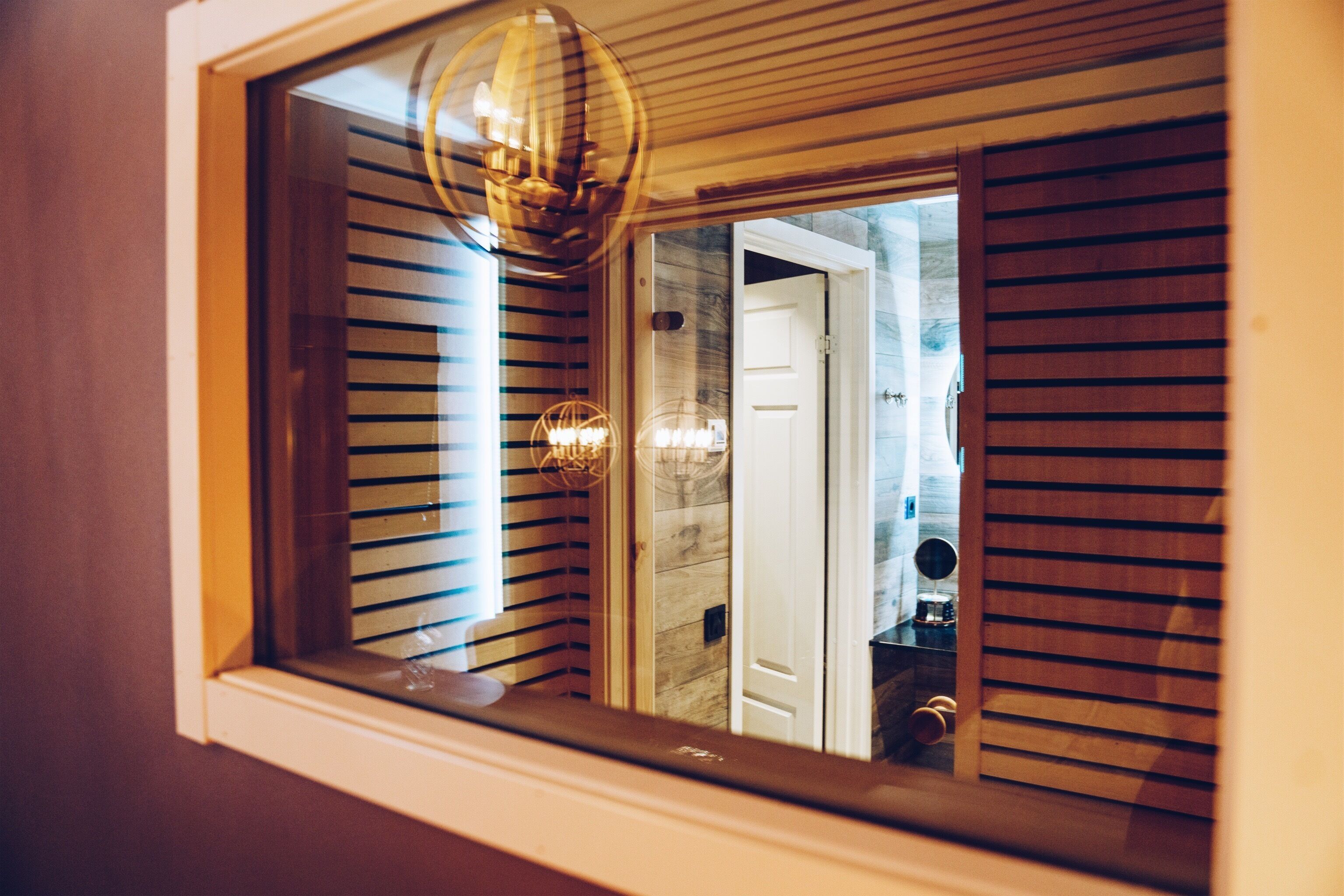 Ein Zimmer mit Fenster, Tür und einer Holzwand.