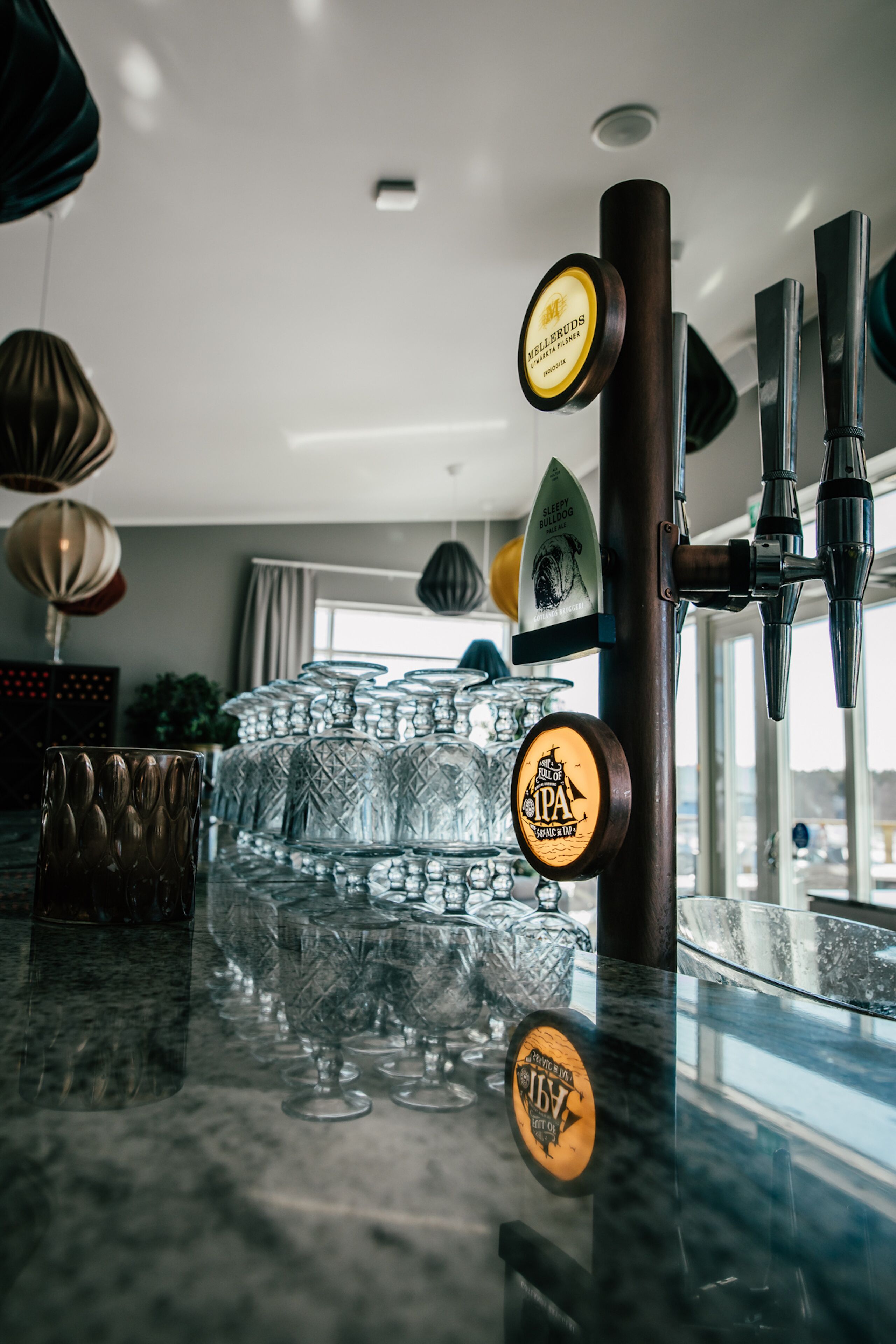 A bar area with multiple taps and glassware.
