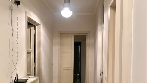 A narrow hallway with a white wall, a white door at the end, and a ceiling light. - Appartamento Sant'Ambrogio nel cuore di Firenze (Florence)