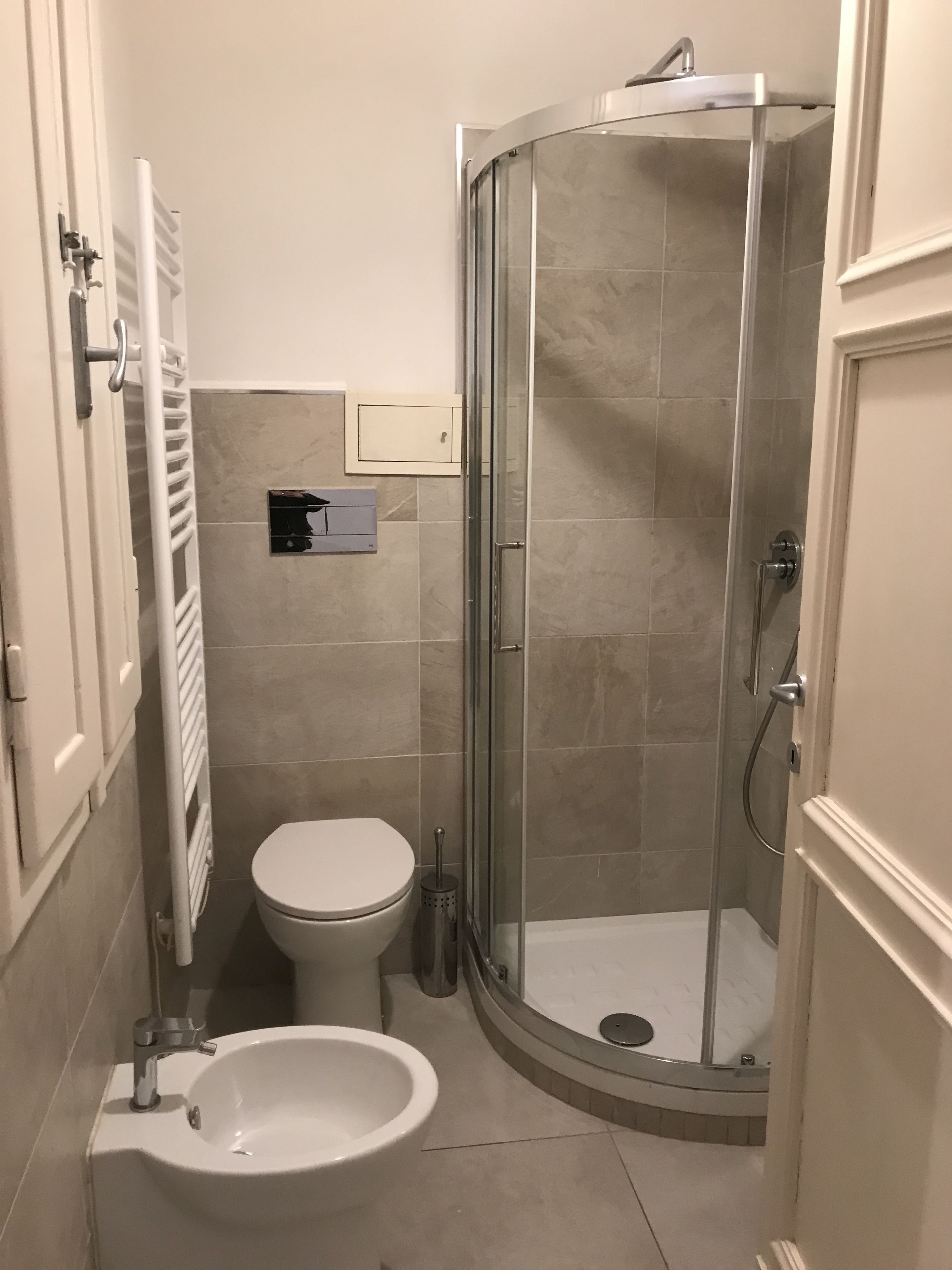 Ein Badezimmer mit Toilette, Bidet und einer Duschkabine.