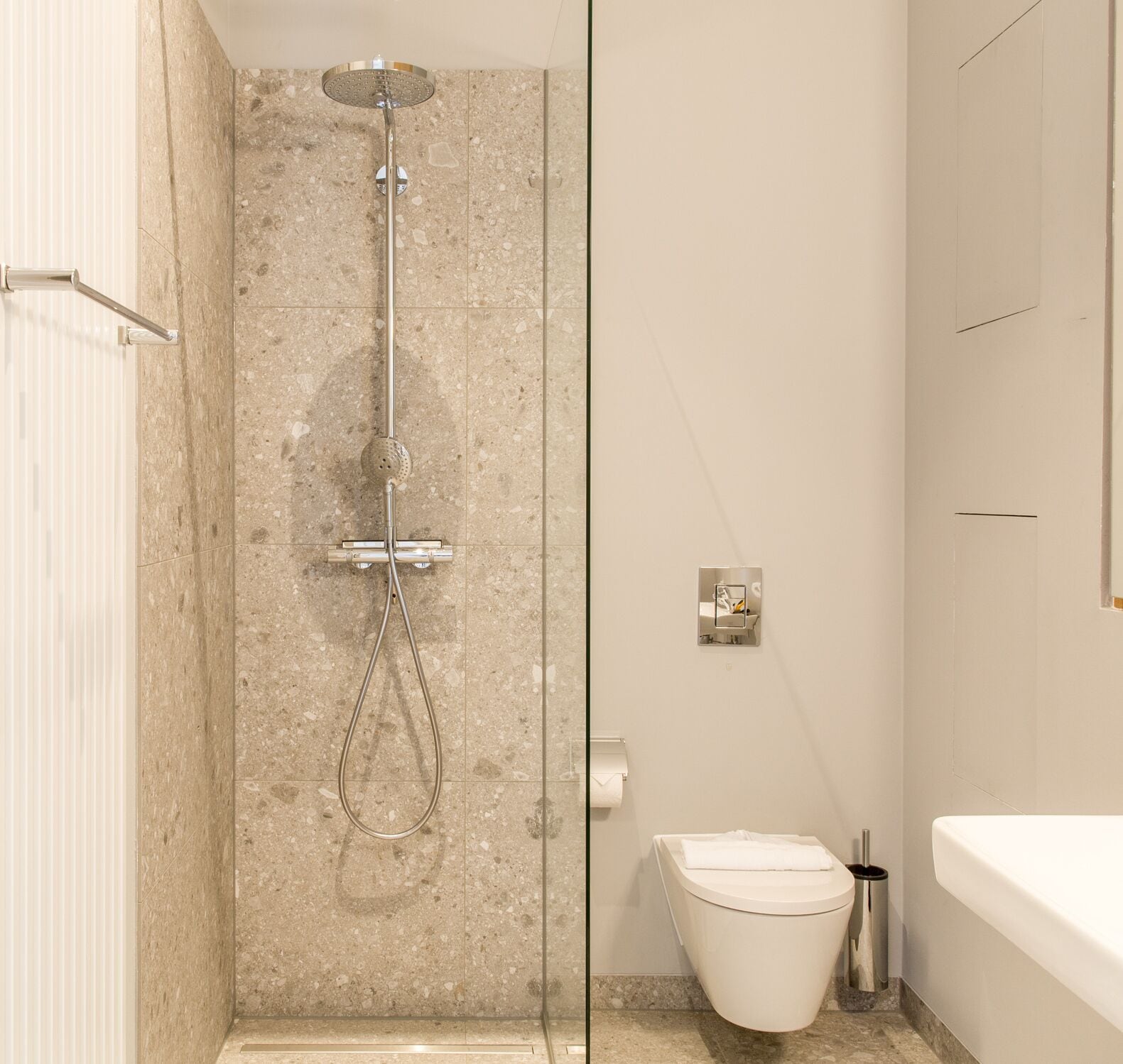 A modern bathroom with a glass-enclosed shower, a toilet, and a bathtub.