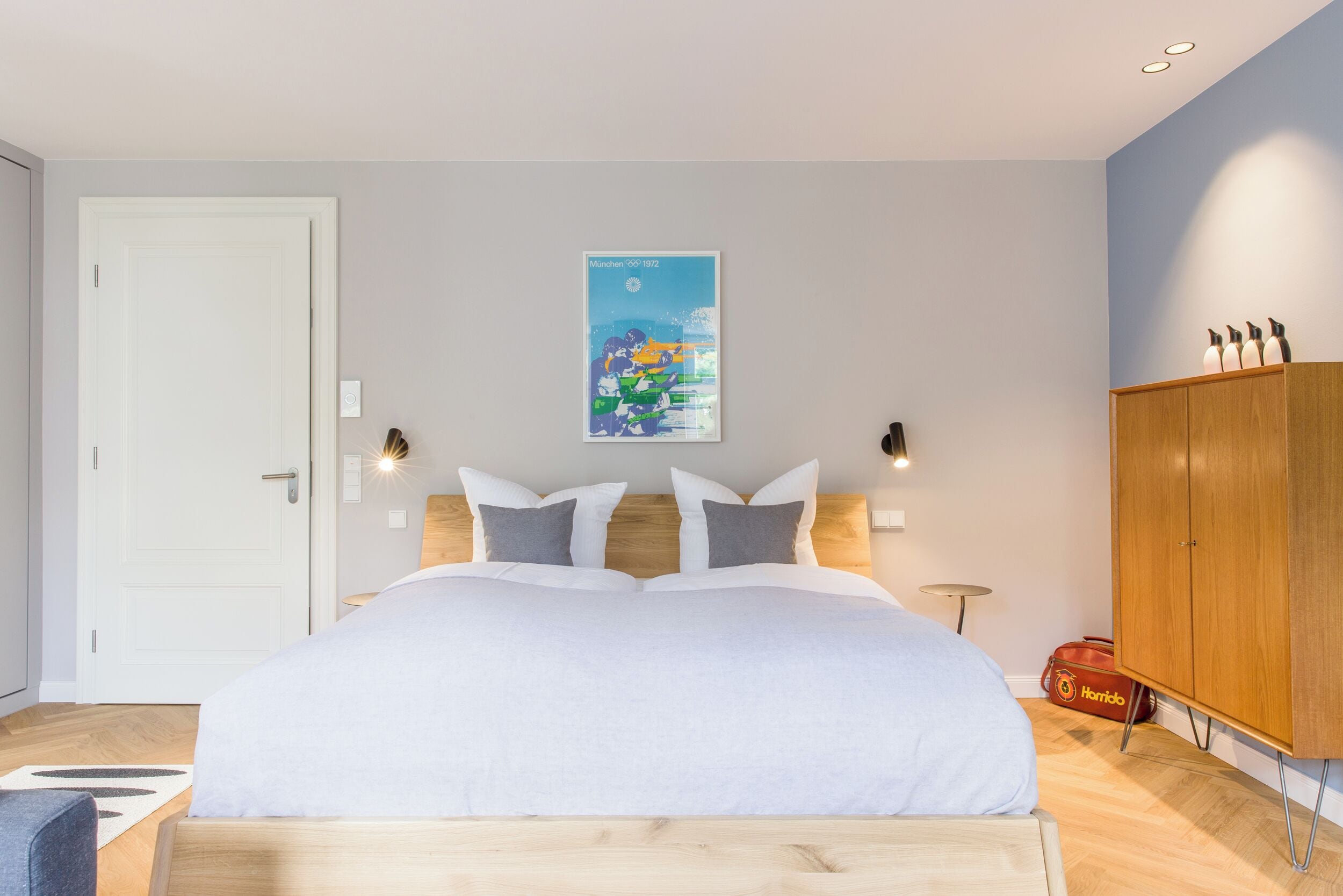 Ein Schlafzimmer mit einem großen Bett, einem Holzschrank und einem Poster an der Wand.