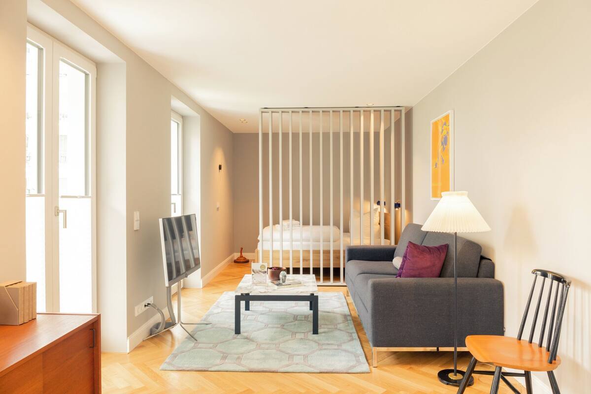 Un salon moderne avec un canapé, une table basse et un téléviseur.