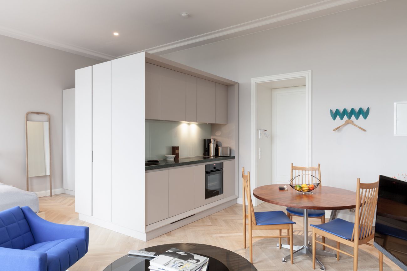 A modern apartment with a kitchen, dining area, and a living room.