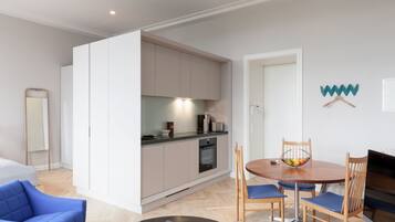 A modern apartment with a kitchen, dining area, and a living room.