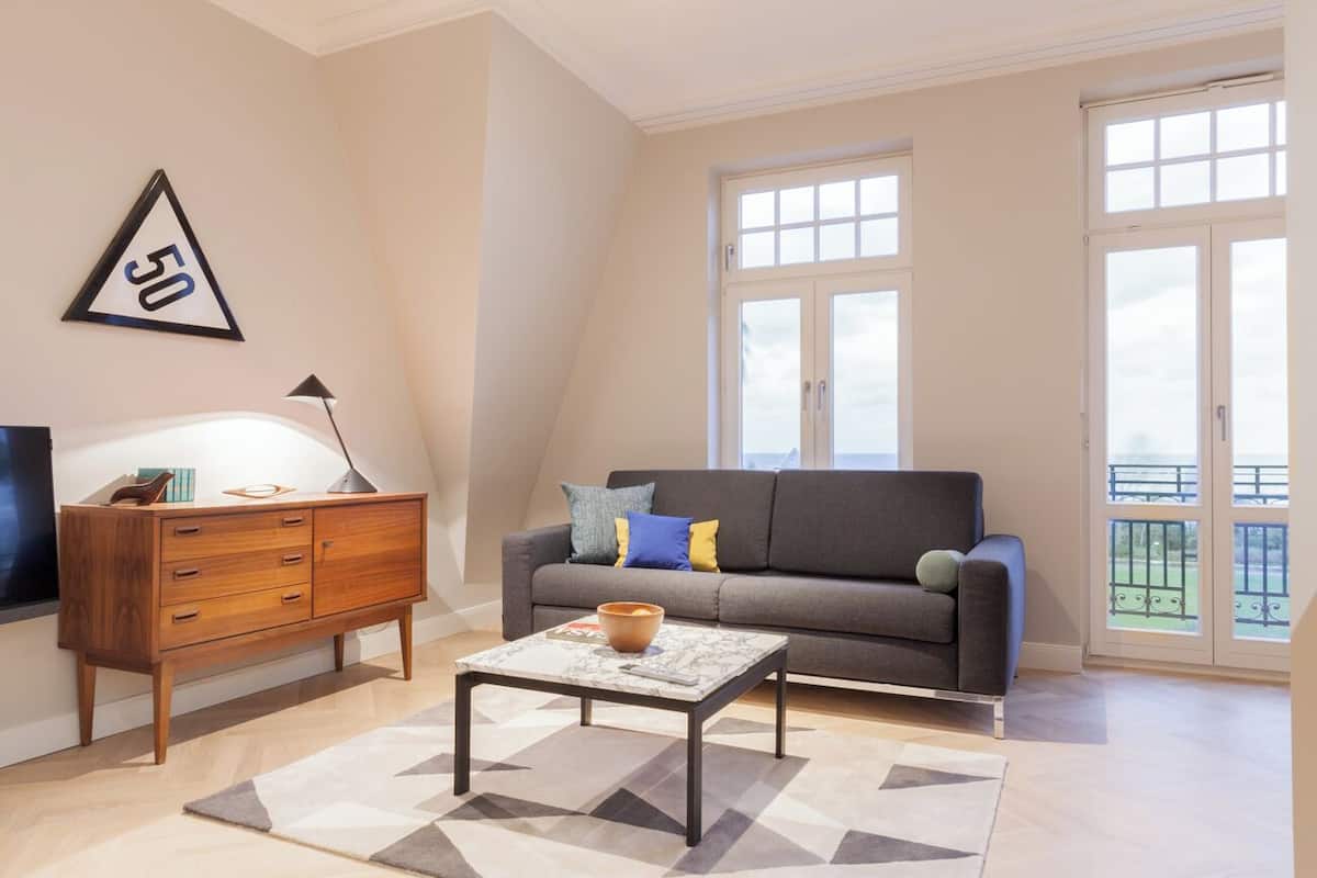 A modern living room with a sofa, coffee table, and wooden cabinet.