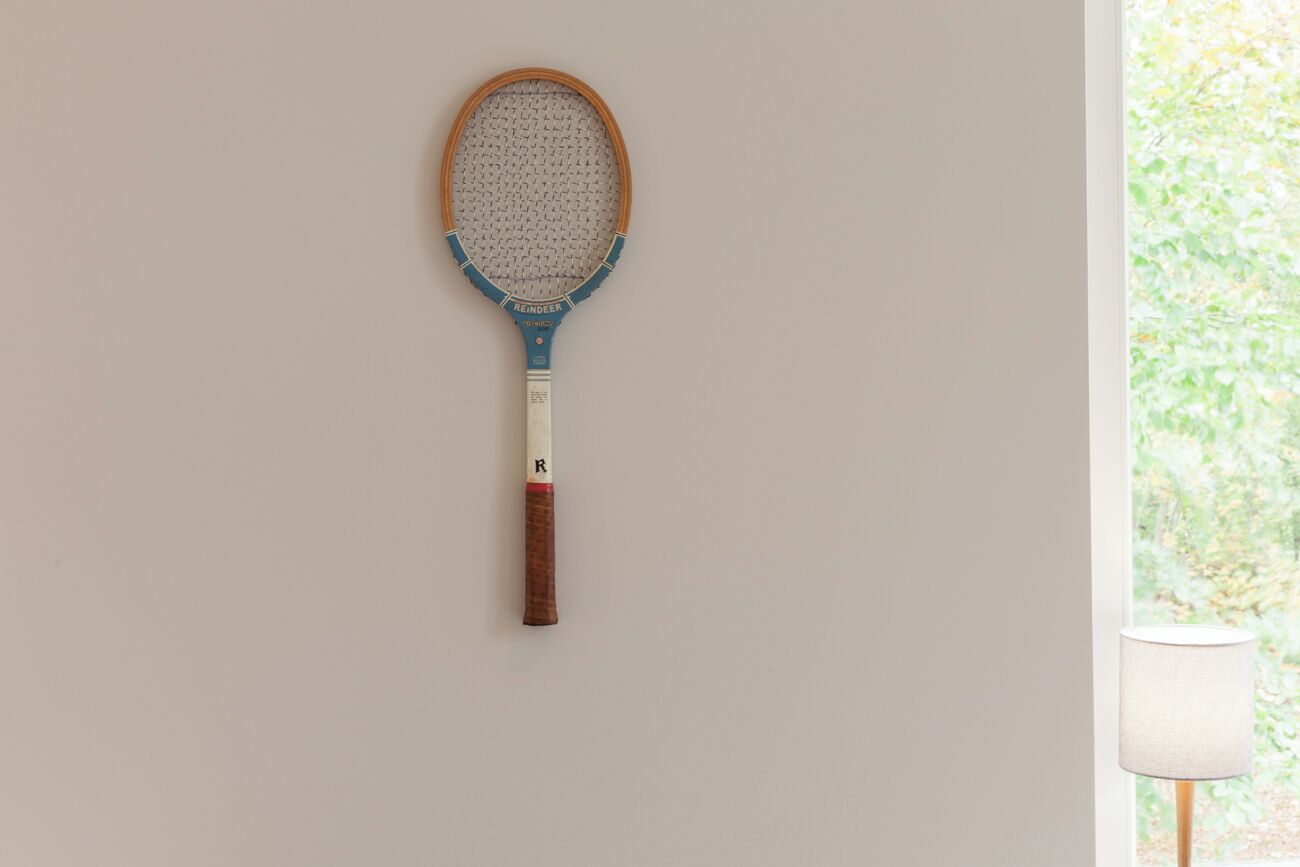 A tennis racket hanging on a wall.