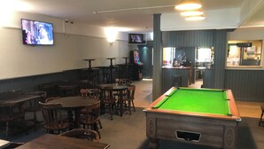 A billiards room with tables and chairs, a pool table, and a bar area. - The Pheasant Inn (Dunstable)