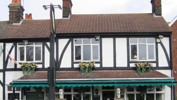 A traditional Tudor-style building with a green awning and flower boxes on the windows. - The Pheasant Inn (Dunstable)