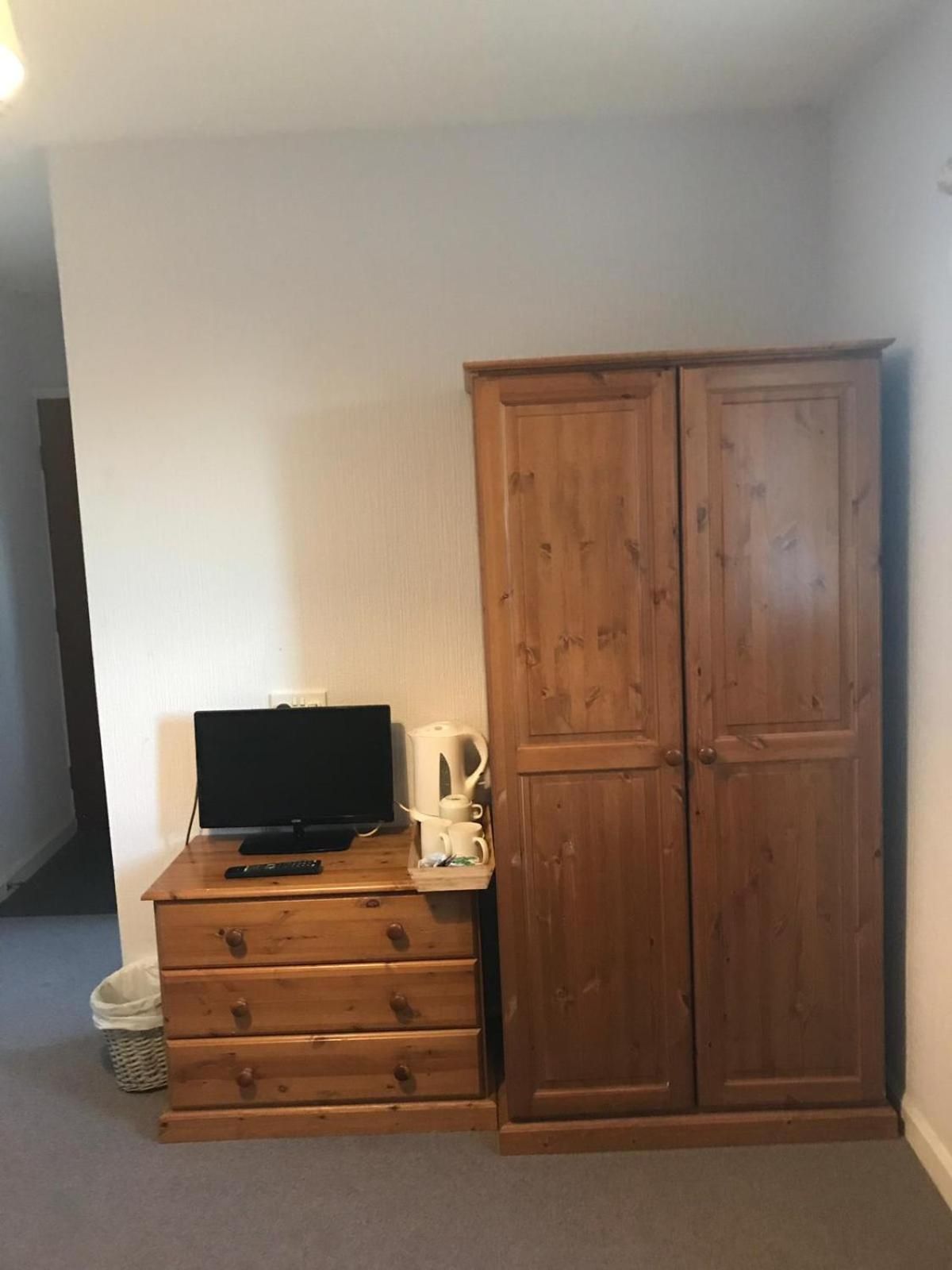 Ein Zimmer mit einem Holzkasten, einem Fernseher und einer Kaffeemaschine.