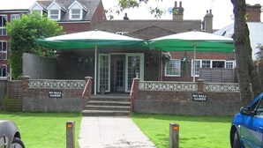 A building with a green awning and a 'NO BALL GAMES' sign on the walls. - The Pheasant Inn (Dunstable)