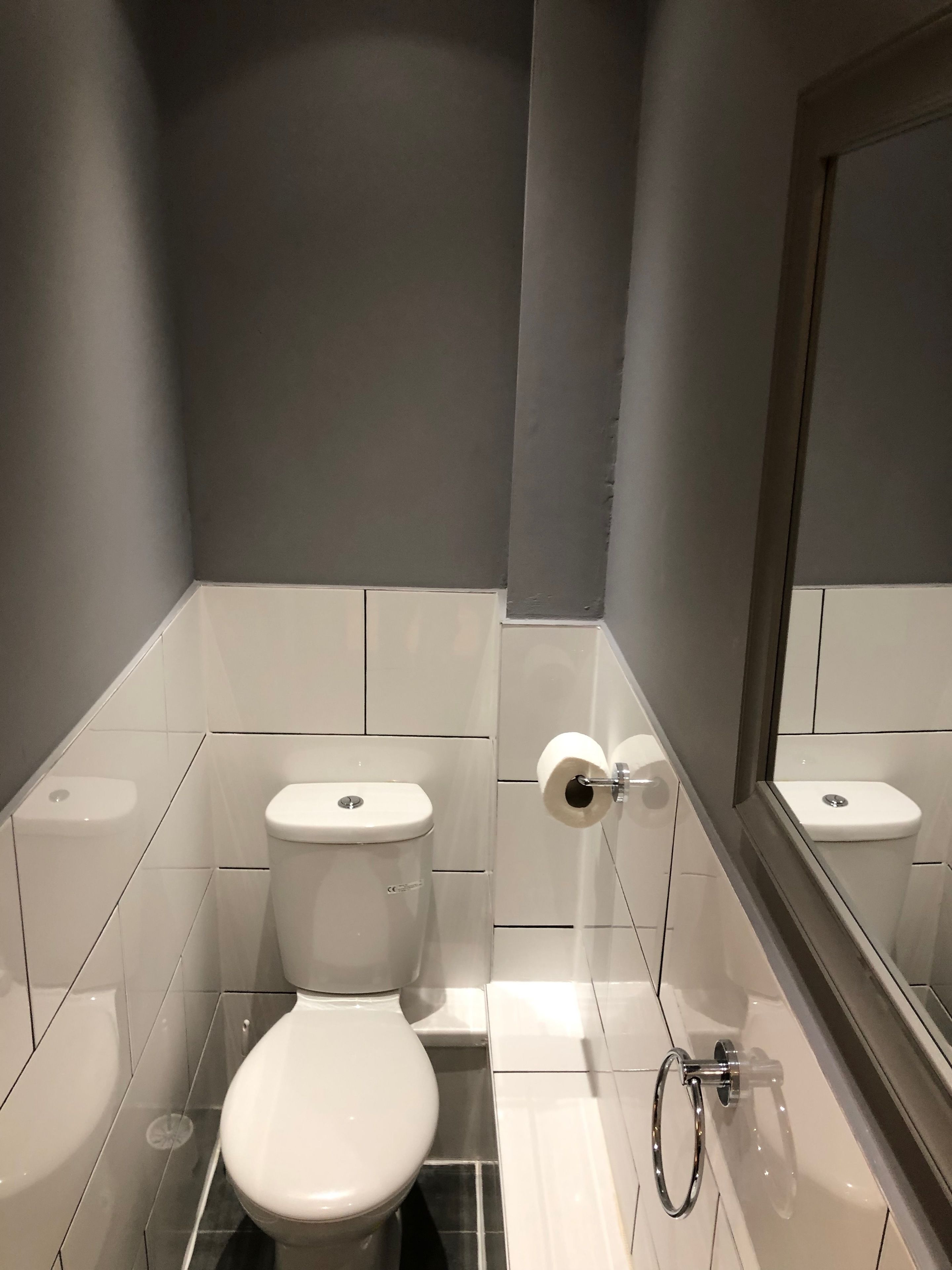 Um banheiro pequeno e moderno, com vaso sanitário, bidê e espelho.