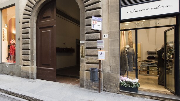 A storefront with a stone archway entrance, a sign for 'cashmere & cashmere', and a mannequin displaying clothing inside. - Vigna Nuova (Florence)