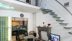 A modern interior with a dining area, kitchen, staircase, and a television. - Vigna Nuova (Florence)