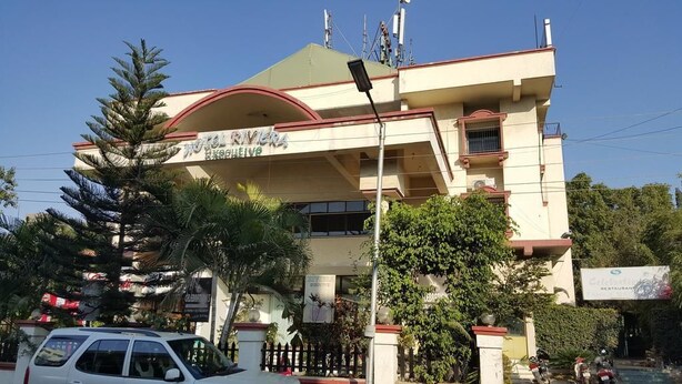 A hotel with a prominent entrance, a sign indicating it is a hotel, and a visible restaurant sign. - Hotel Riviera Executive (Chhatrapati Sambhajinagar)