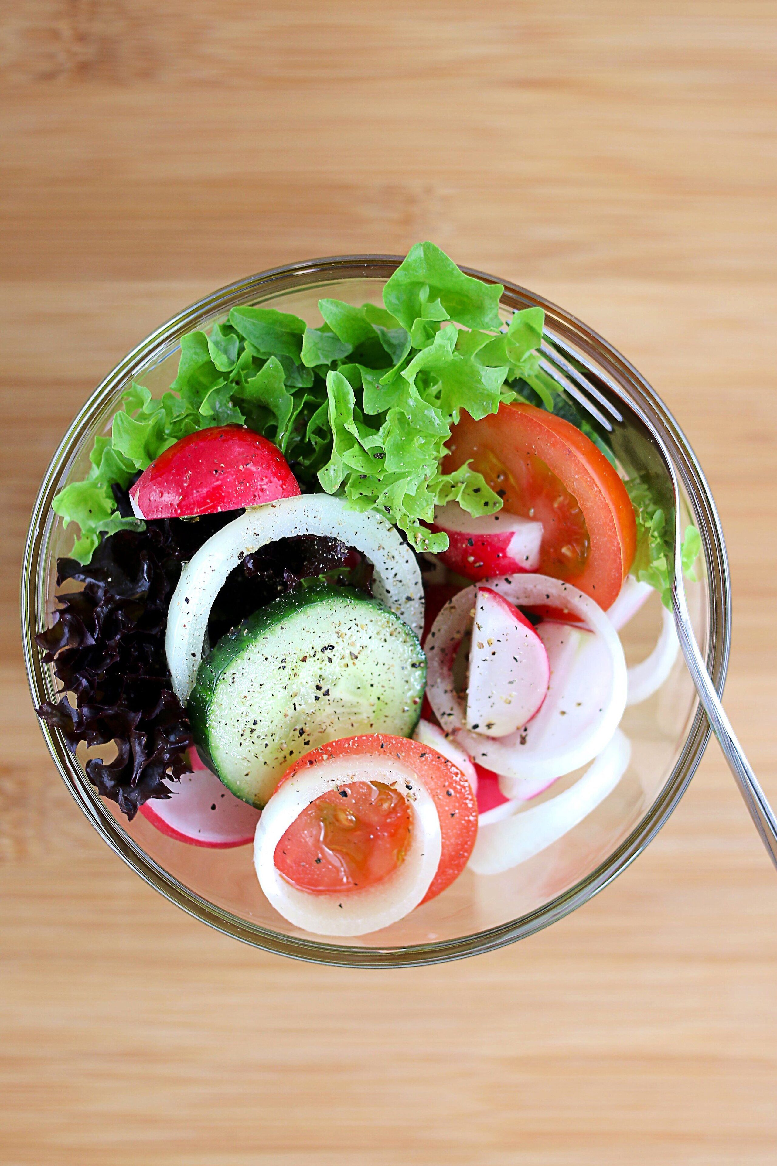 A clear view of a salad bowl with various vegetables.