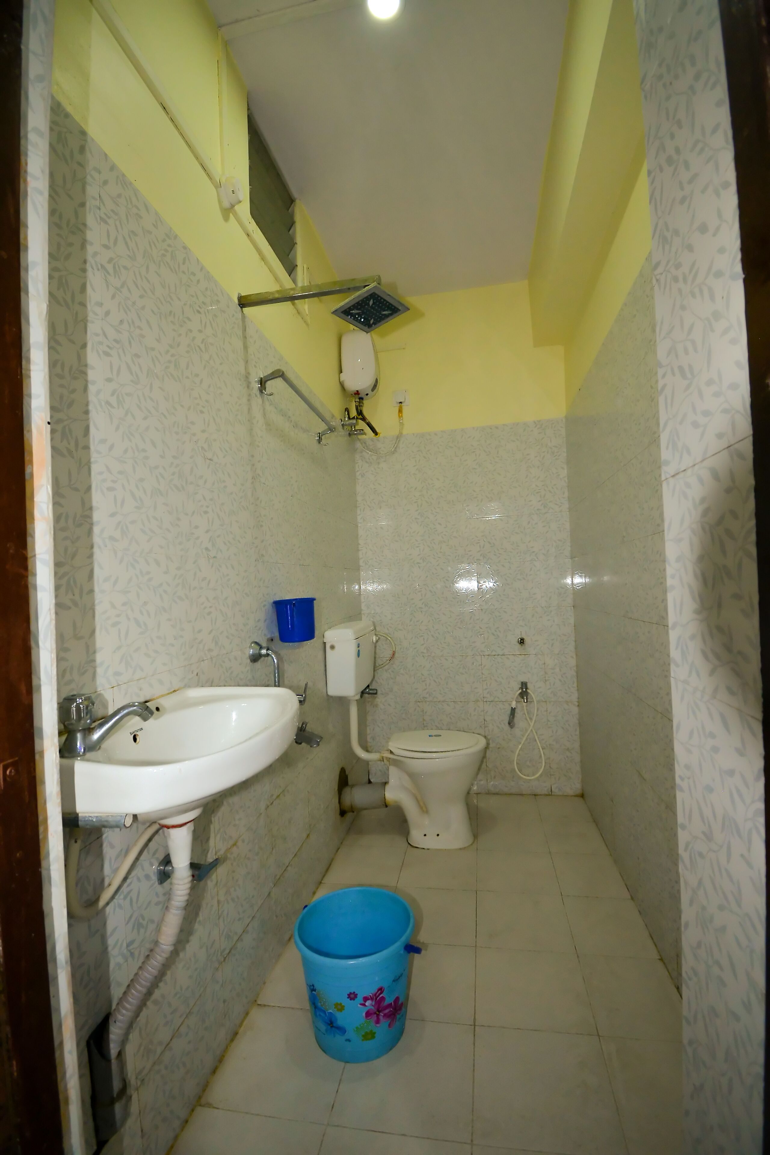 A small bathroom with a sink, toilet, and shower.