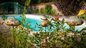 Una piscina techada, una piscina al aire libre de temporada, sombrillas