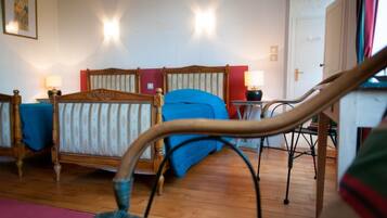Ein Schlafzimmer mit einem hölzernen Bett, einem blauen Sessel und Holzboden.