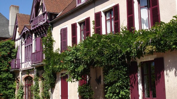 A traditional European-style building with red shutters and a balcony. - Au Puy des Vérités (Lapalisse)