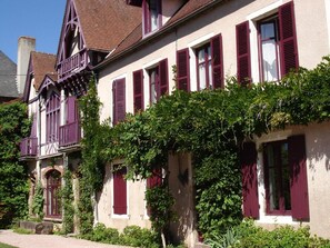Un bâtiment de style européen traditionnel, avec des volets rouges et un balcon.