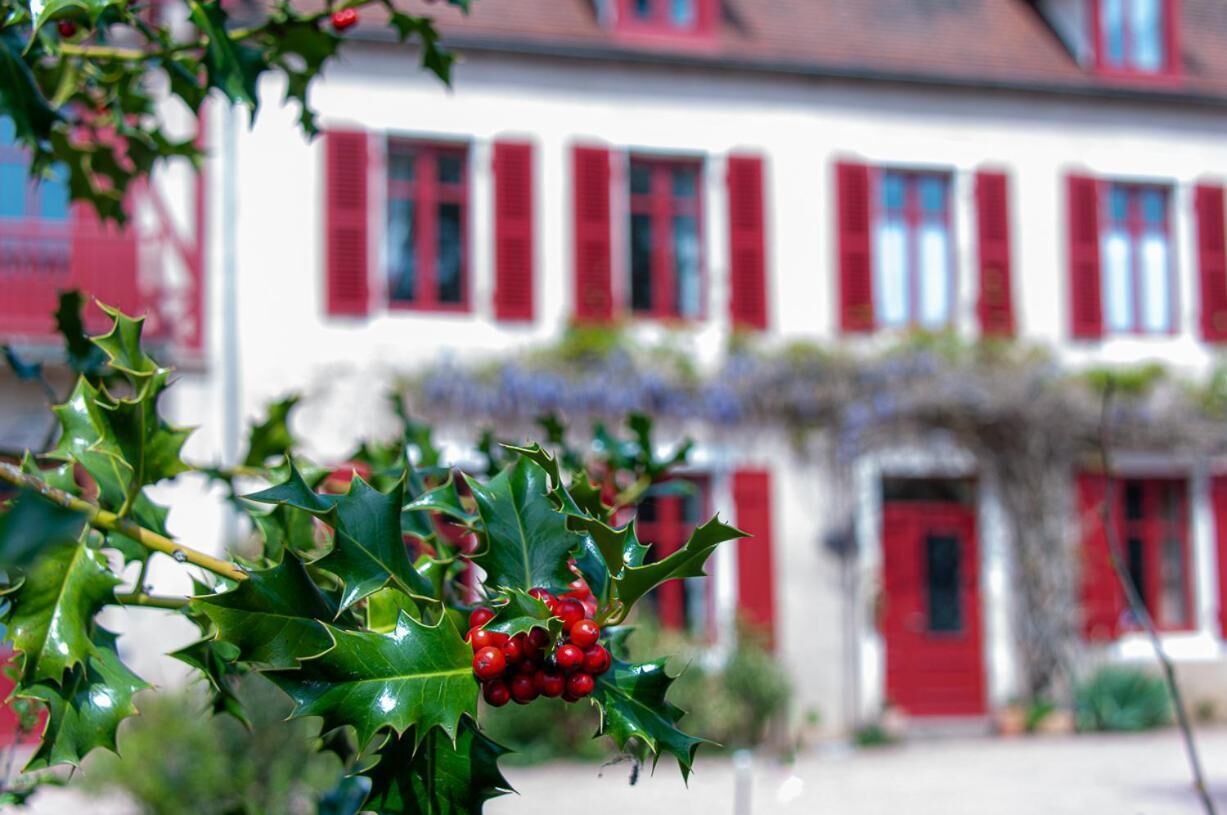 Un bâtiment avec des volets rouges et une façade blanche.