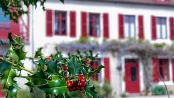 Un bâtiment avec des volets rouges et une façade blanche.