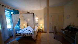A bedroom with a four-poster bed, a desk, and a chair. - Au Puy des Vérités (Lapalisse)