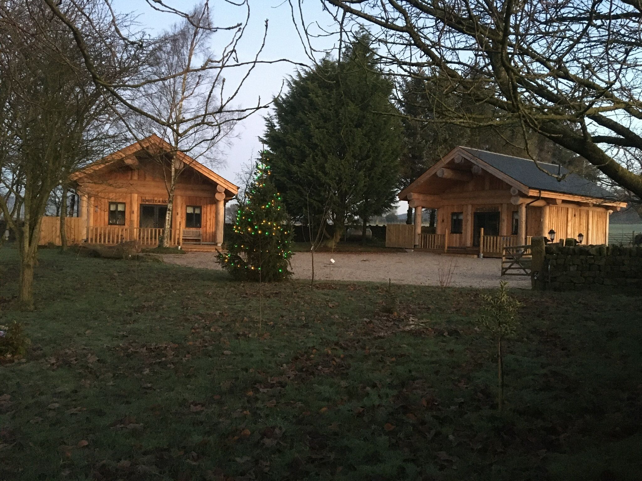 Dos cabañas de madera con un árbol de Navidad en el medio.