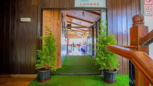 A wooden hallway leading to a lounge area with a sign reading "sky LOUNGE." - Nitya Resort (Calangute)