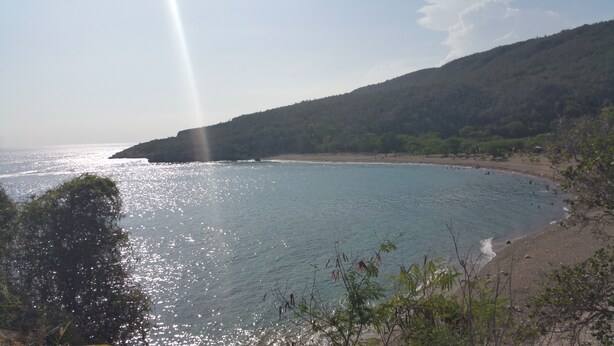 A coastal landscape with a beach, clear sky, and a mountain in the background. - CASA GLORIA (Santiago de Cuba)