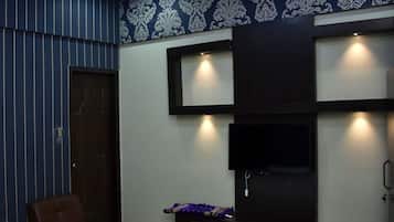 A modern room with a TV mounted on the wall, a brown leather chair, and a patterned wallpaper design.