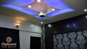 A ceiling with a modern design featuring recessed lighting and a central fan.