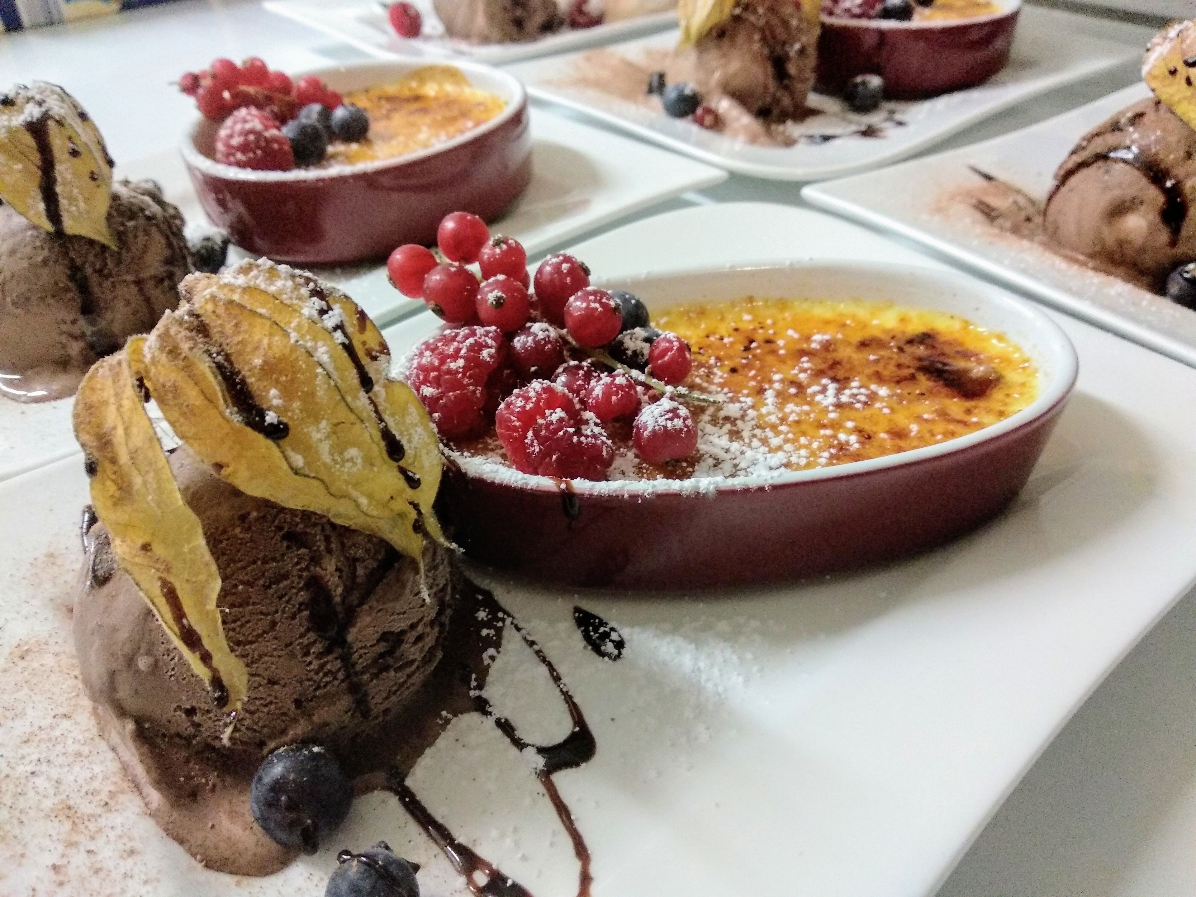 Een nagerechtopstelling met chocolademousse, frambozen en een plak banaan.