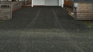 Een woonhuis met twee verdiepingen, een garage, een oprit en een houten hek met het nummer 4864.
